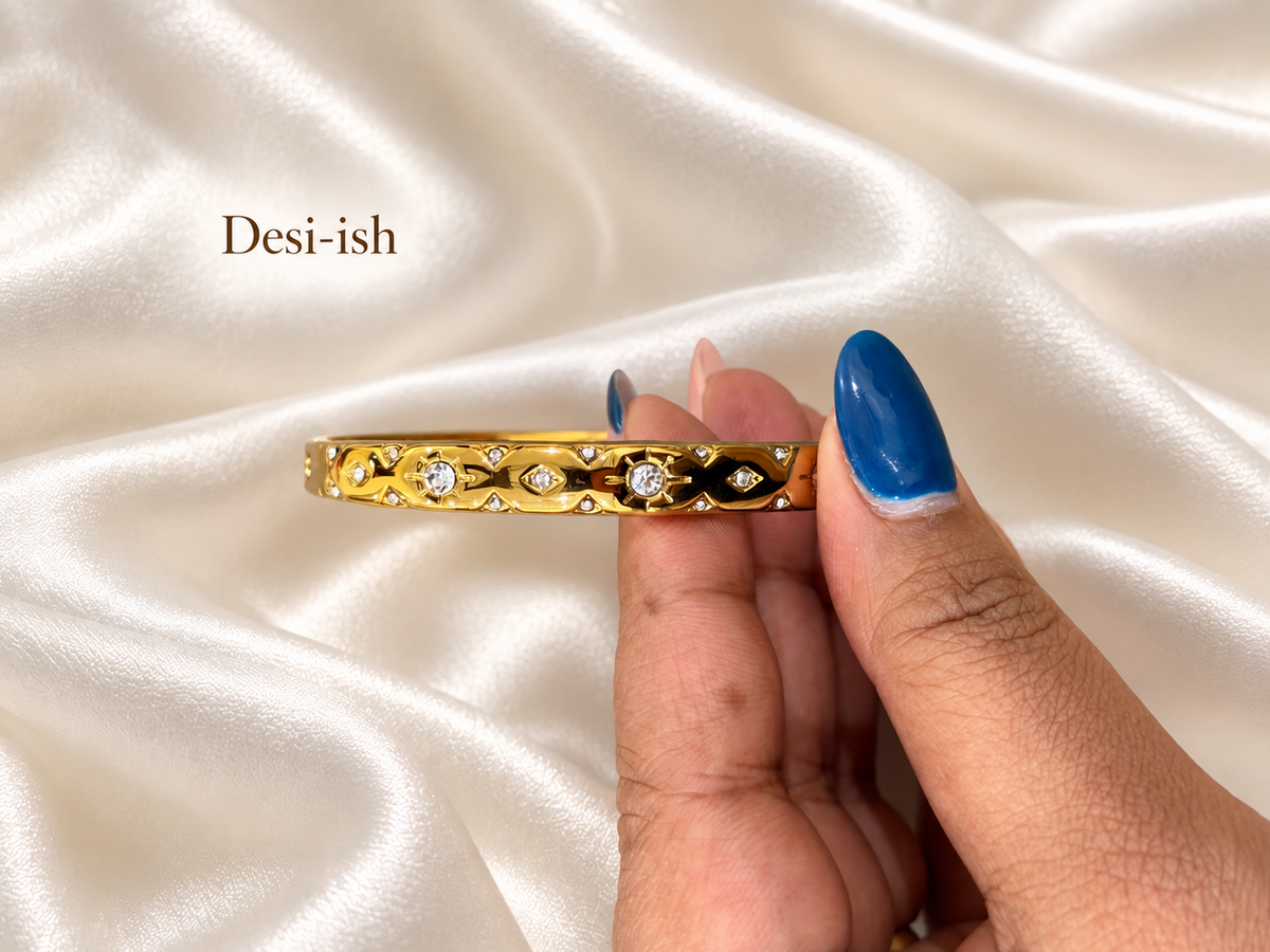 Crystal Gaze Kada held close up against white satin